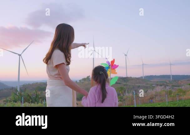 Woman Pointing Girl Holding Pinwheel Observing Wind Turbines At Woman Pointing Girl Holding Pinwheel Observing Wind Turbines At