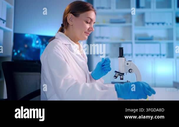 Lab Id Format A woman in a lab coat and blue gloves is working with a microscope in a ...