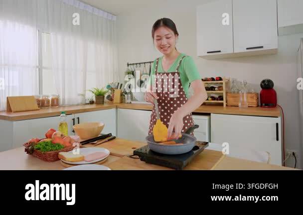 Woman cooking in kitchen wearing apron smiling Stock Video Footage - Alamy