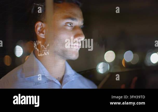 Glanicing Analyst glancing at tablet in night office, starting finance charts on ...