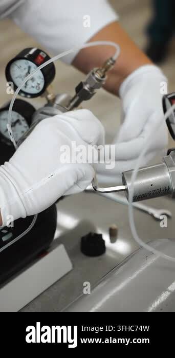 Laboratory technician adjusts pressure control equipment with gauges ...