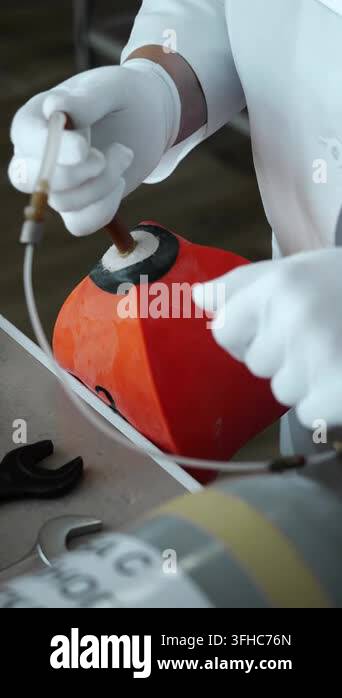 Laboratory technician connects flexible tubing to a sealed sample ...