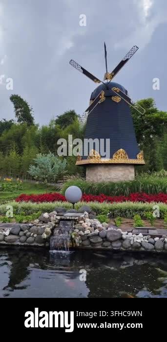 Vector Fish Pond Scenic view of a traditional black and gold windmill in a beautiful ...