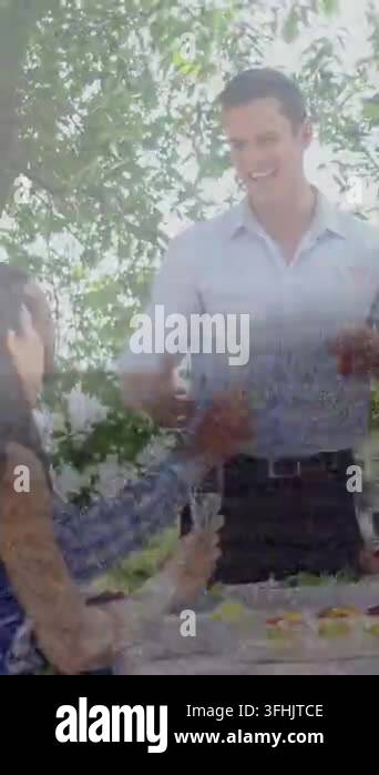 Vertical video: Man offering flutes under trees, causing guests raising ...