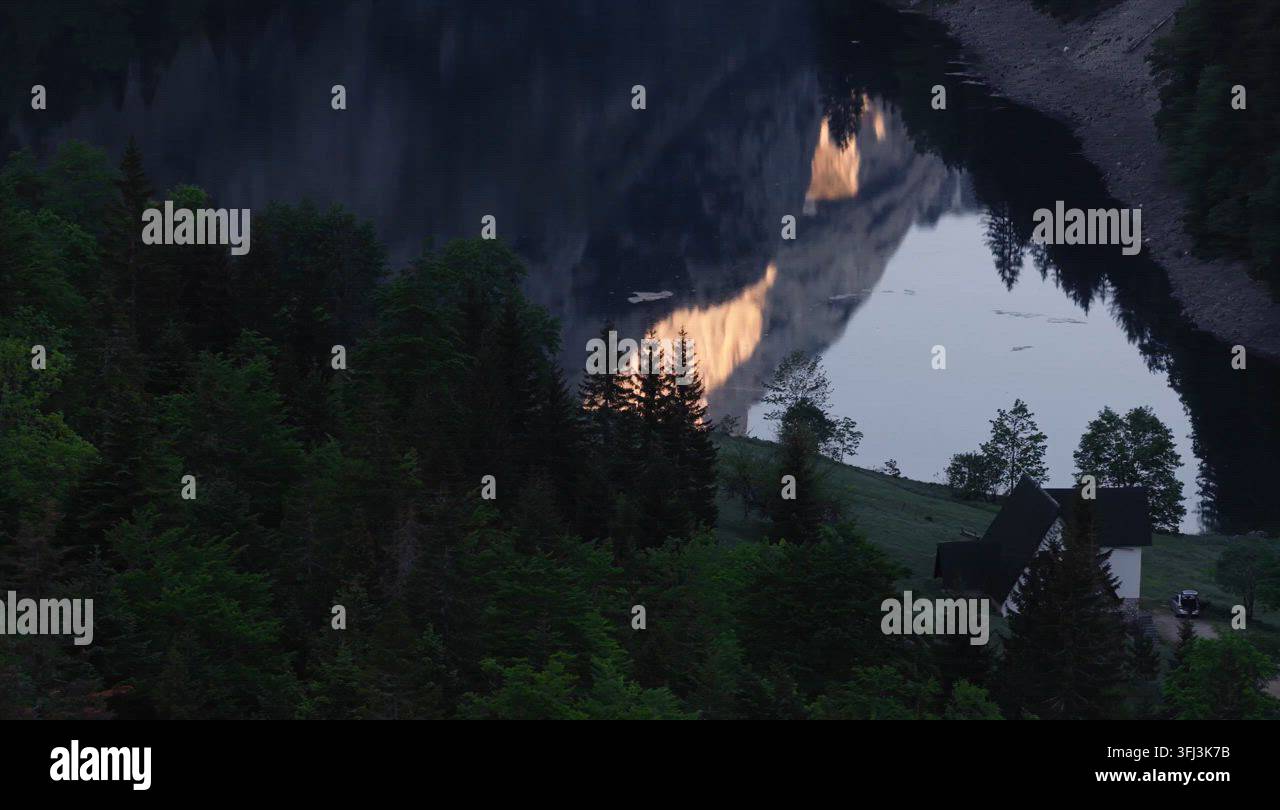 Alpenglow Reflected In A Dark Mountain Lake At Dusk Stock Video Footage Alpenglow Reflected In A Dark Mountain Lake At Dusk Stock Video Footage