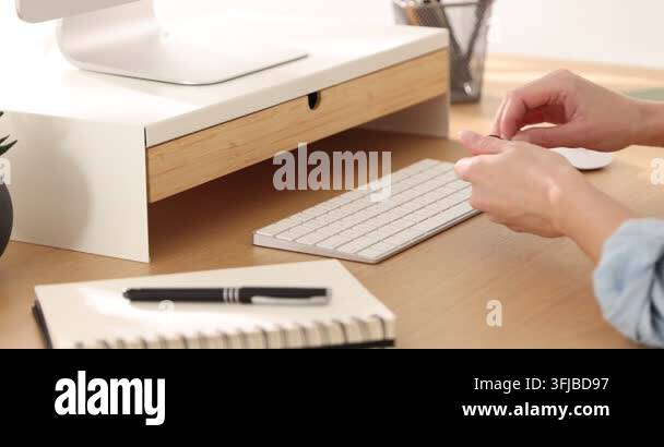 Computer Sdreem Riser Woman putting glasses into drawer of under monitor riser at wooden desk ...
