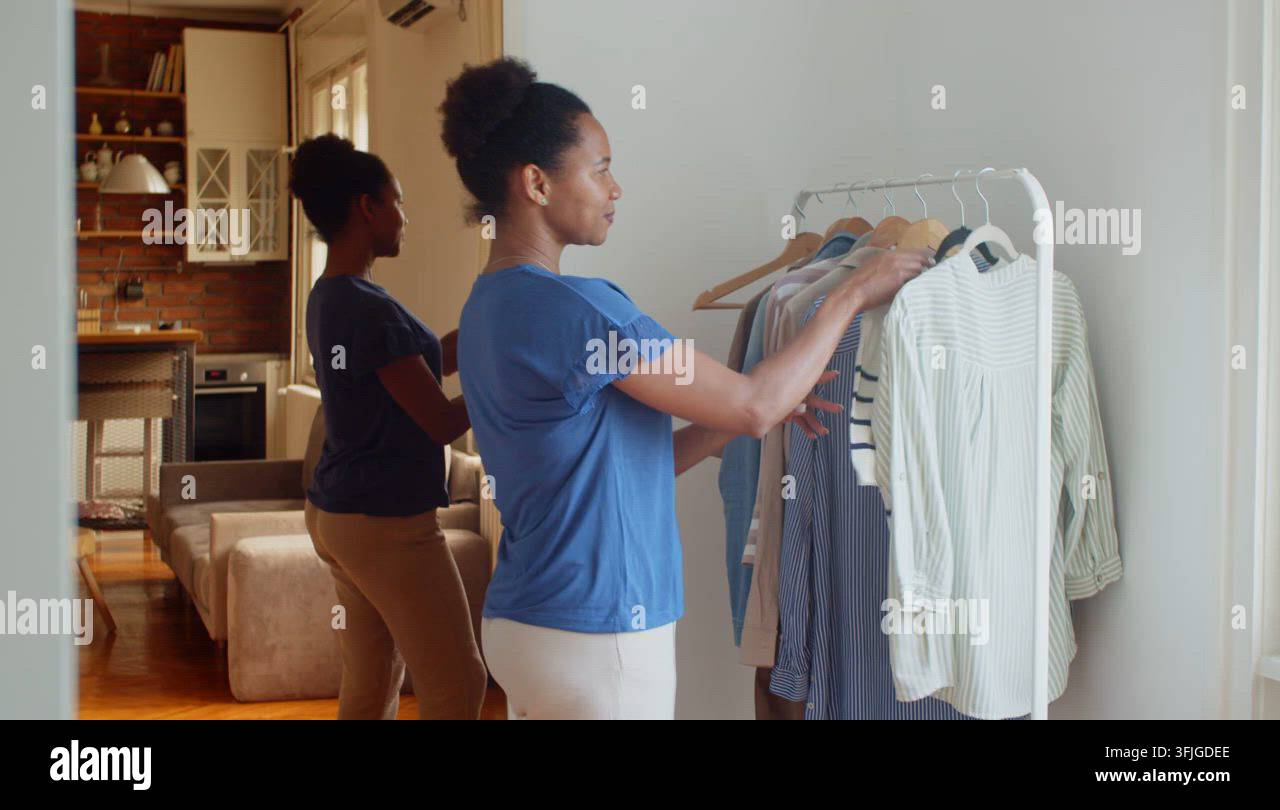 Woman is choosing clothes from a hanger Stock Video Footage - Alamy
