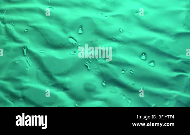 Close-up view of crumpled textured fabric with visible water droplets ...
