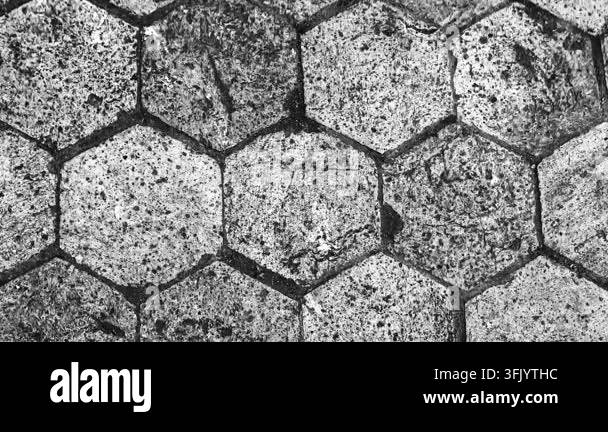 Close-up view of weathered hexagonal stone paving with a rough ...