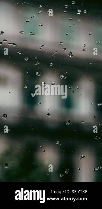 Clear water droplets cling to a glass surface, creating abstract ...