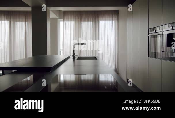 A contemporary kitchen showcasing a sleek black countertop, built-in ...