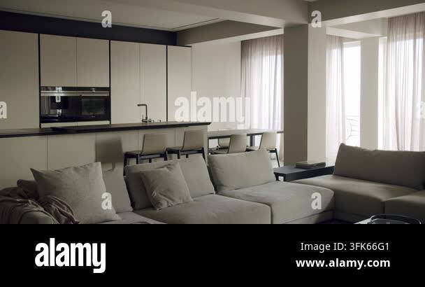 Elegant and modern living room seamlessly connected to a kitchen space ...