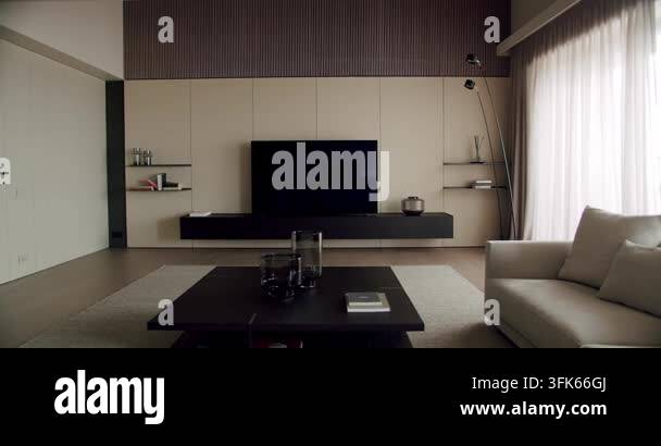 A sleek minimalist living room featuring a large flat-screen TV ...