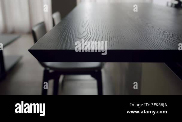 Focus on a stylish black wooden table in a contemporary dining room ...