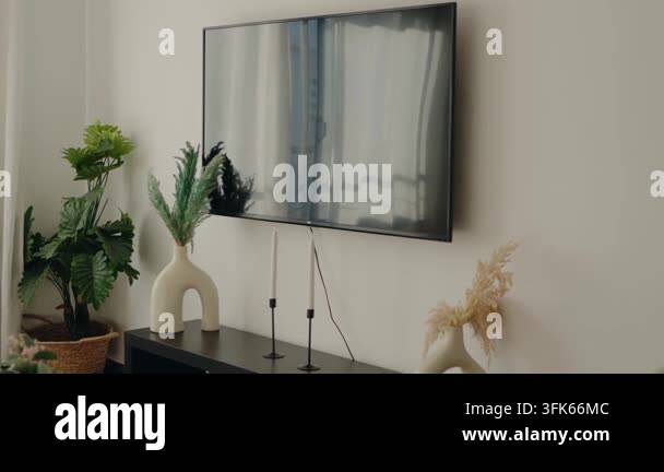 A modern living room with a flat-screen TV mounted on a white wall ...