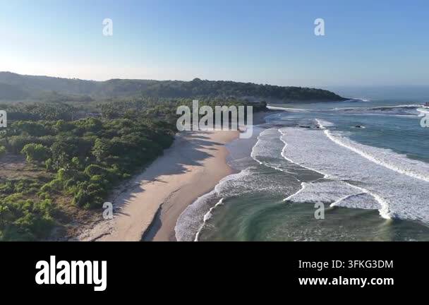 Aerial drone view of a tropical beach bay, turquoise water rolling into ...
