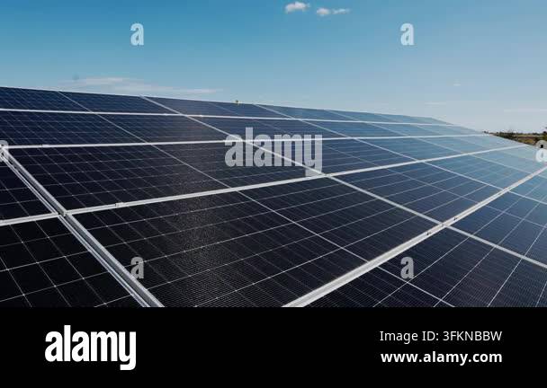 Close-up aerial view of a large solar panel array under a clear blue ...