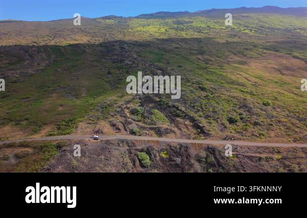 Lava Racks Aerial view of white pickup truck driving lonely cliffside highway ...