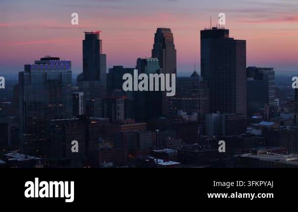 Aerial view of a modern city skyline at dusk with illuminated ...