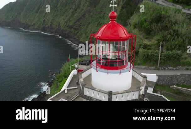 Aerial view of a lighthouse with a red roof on a cliff overlooking the ...