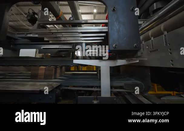 Dark metal rails, rollers, belts, wiring, and brackets form complex ...