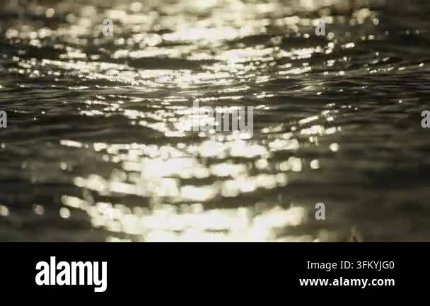 Sunlight reflecting on shimmering water surface Stock Video Footage - Alamy