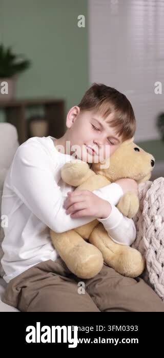 Little boy with his teddy bear on sofa at home Stock Video Footage - Alamy