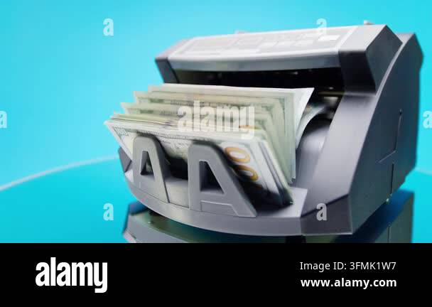 Angled view features money counter with US dollar bill stack in feeder ...
