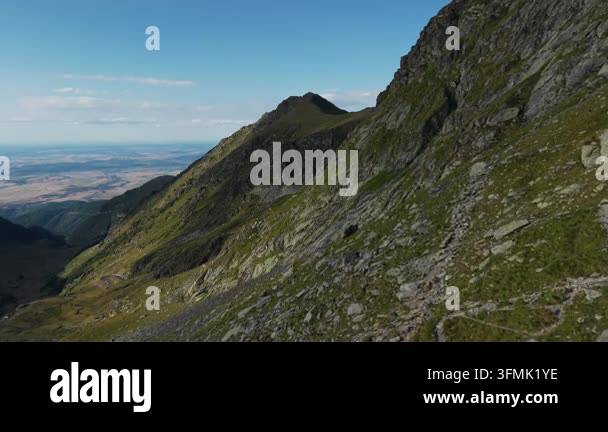 Clear summer conditions frame mountain summit view across distant ...