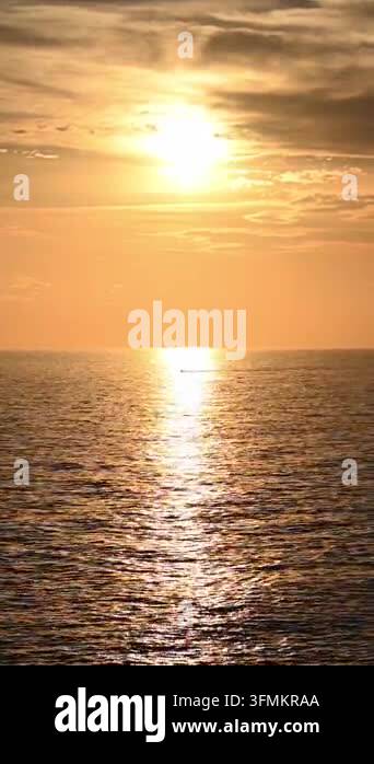 Sun setting over calm sea with golden reflection on water Stock Video ...