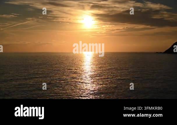 Sun setting over calm sea with golden reflection on water Stock Video ...