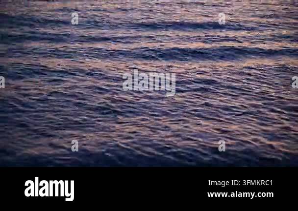 Sea surface rippling and reflecting sunset light over open water Stock ...