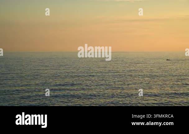 people paddling small boat on calm sea at sunset Stock Video Footage ...