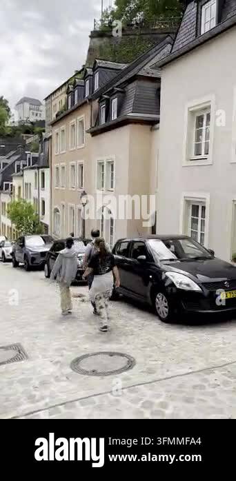 Historic european cobblestone street with old buildings and cars ...