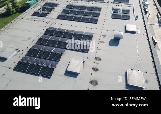 Aerial drone view of photovoltaic solar panels mounted on the flat roof ...
