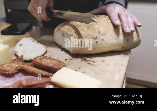 Hands slicing a loaf of crusty bread on a wooden board Stock Video ...