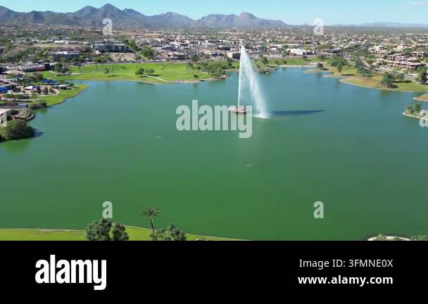 Aerial view of scenic lake with fountain and surrounding mountains ...