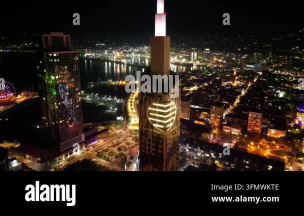 Aerial view of illuminated skyscrapers and city lights at night, with a ...