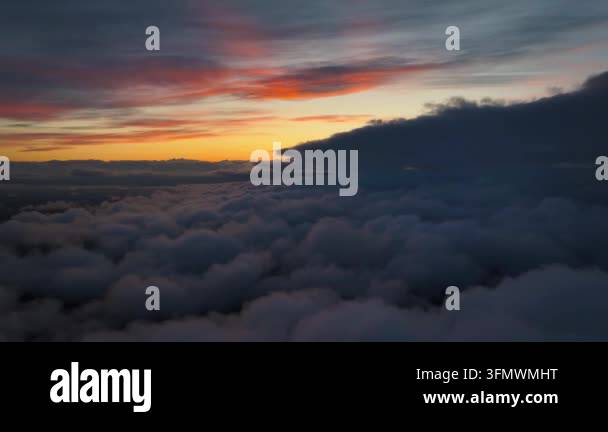 Aerial view of a dramatic sunset sky above a sea of clouds, with ...