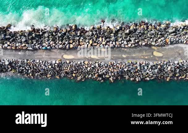 Aerial downward video of waves lapping against the North Shore ...