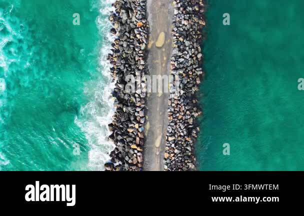 Aerial downward video of waves lapping against the North Shore ...
