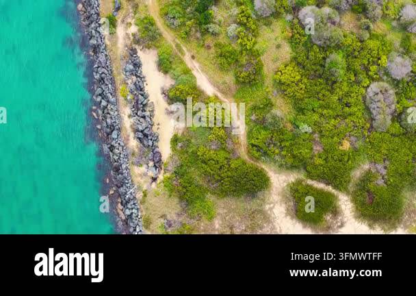 Aerial downward video of waves lapping against the North Shore ...