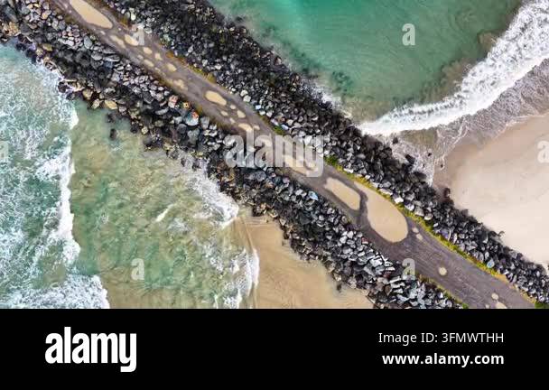 Aerial downward video of waves lapping against the North Shore ...