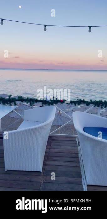 An empty outdoor dining area at a coastal restaurant, featuring white ...