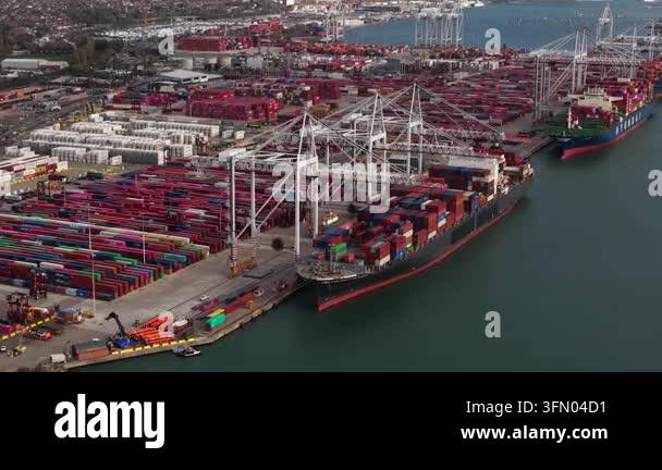 Aerial view of a massive container ship docked at a busy port, with ...