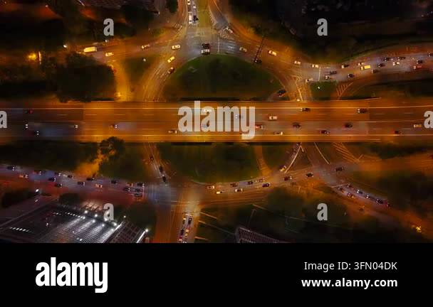 Aerial view of a busy highway interchange at night with cars moving and ...
