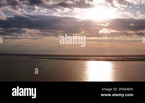 Aerial drone footage captures a serene lake at sunset with dramatic ...
