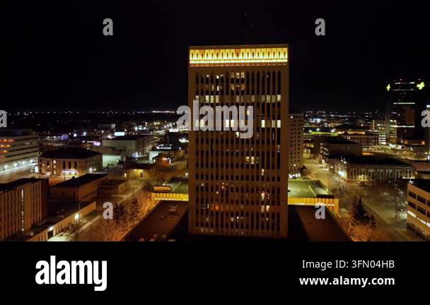 Tall modern office building illuminated at night in urban city Stock ...