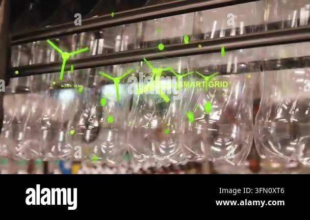 Row of bottles vibrating on rail in factory, camera panning and ...