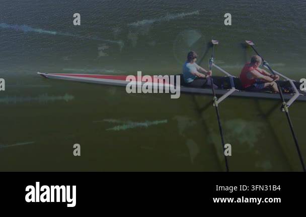 Male stroke, female bow sculling on green water, steady strokes causing ...